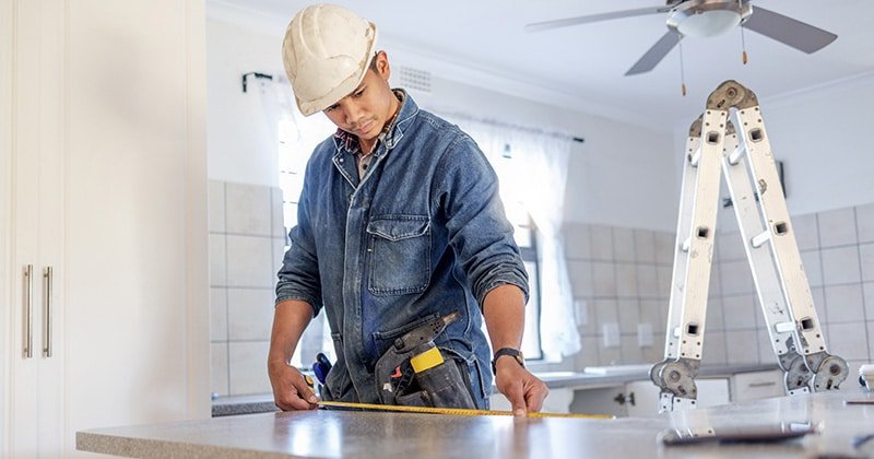 Contractor measuring a kitchen countertop before a remodel
